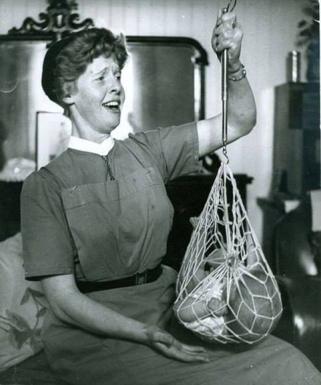 Медсестра взвешивает младенца в шотландской деревушке. Шотландия, 1959 год. Медсестра взвешивает младенца в шотландской деревушке Шотландия 1959 год